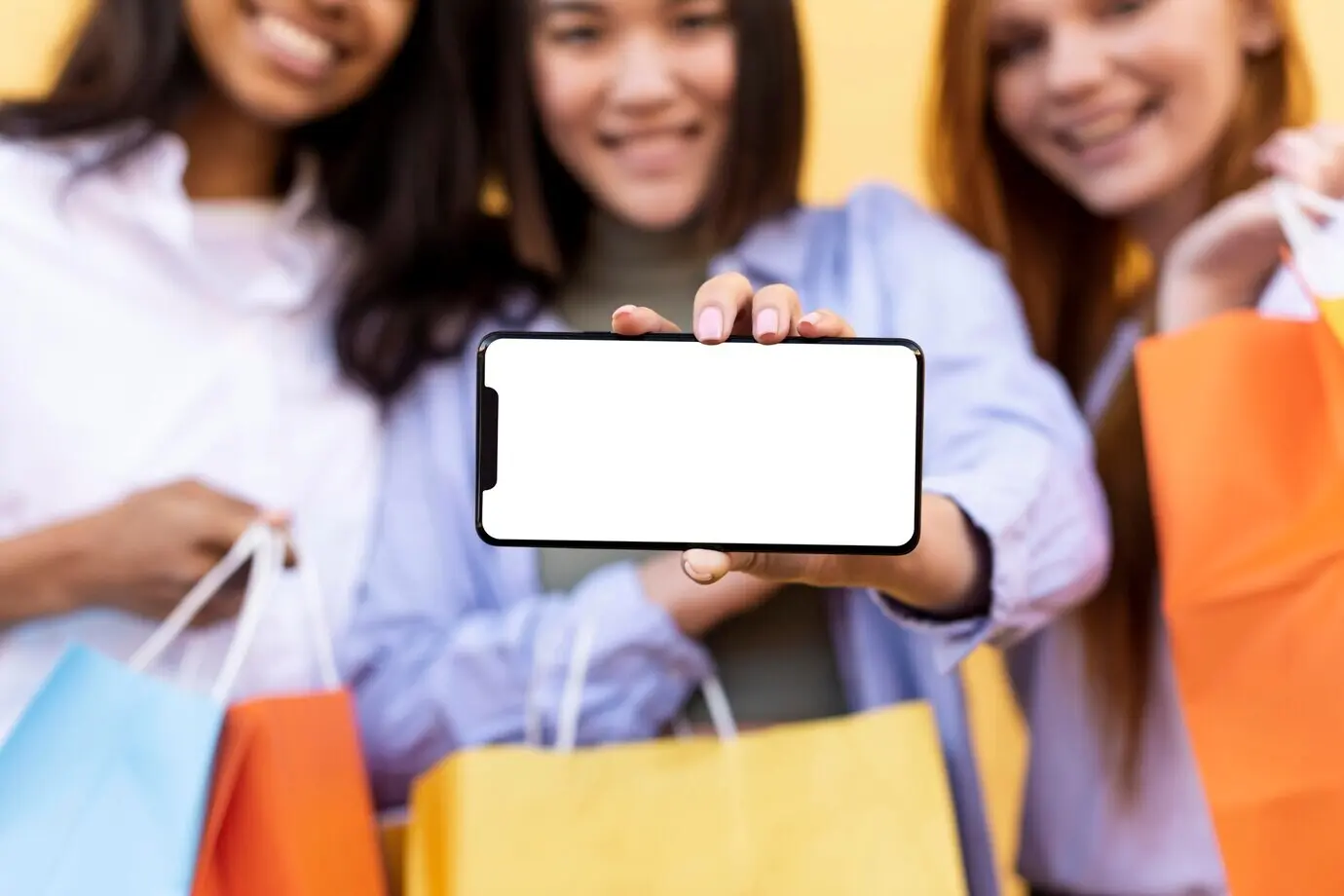 Лучшие друзья держат сумки для покупок и телефон с пустым экраном.